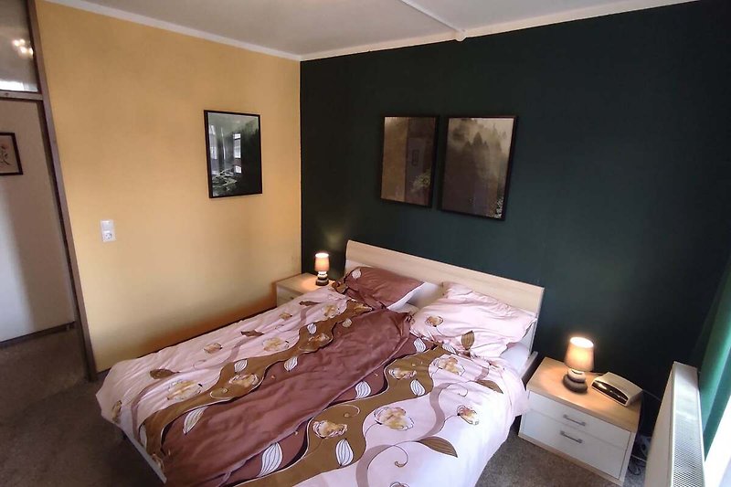 Schlafzimmer mit gemütlichem Bett und Kerzen.