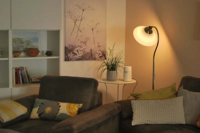 Gezellige woonkamer met geel interieur en houten meubels.