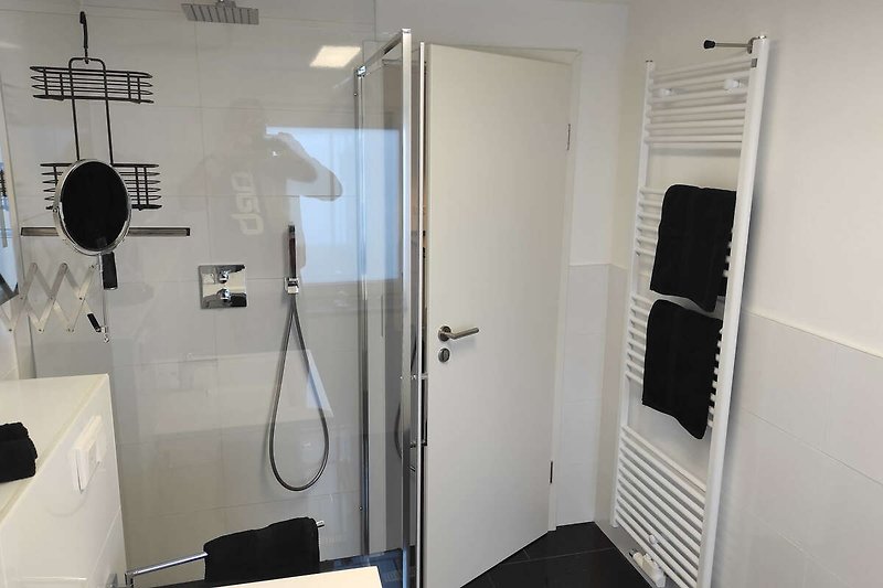 Modernes Badezimmer mit Glasduschtür und Aluminiumarmaturen.