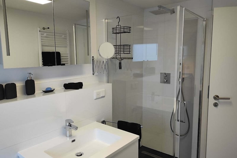 Elegantes Badezimmer mit Glaswaschbecken und Dusche.