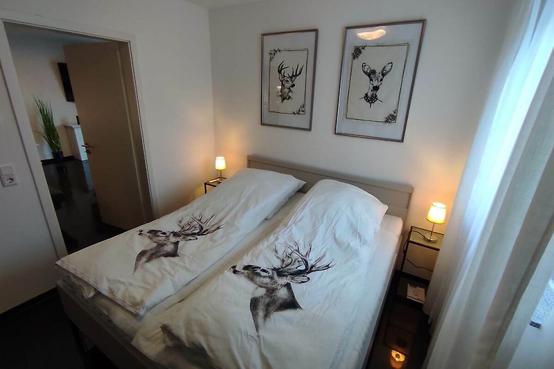 Elegantes Schlafzimmer mit stilvollem Bett und dekorativer Beleuchtung.