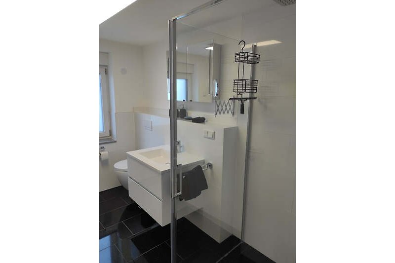Modernes Badezimmer mit Glaswaschbecken und Metallarmaturen.
