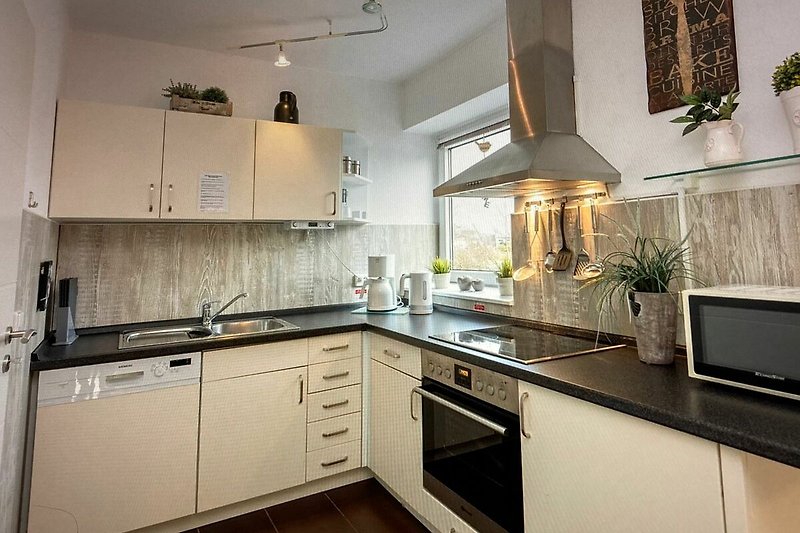 Moderne Küche mit stilvoller Beleuchtung, Holzboden und hochwertigen Geräten.