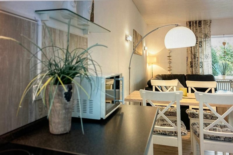 Einladendes Wohnzimmer mit stilvollen Möbeln und Pflanzendeko.