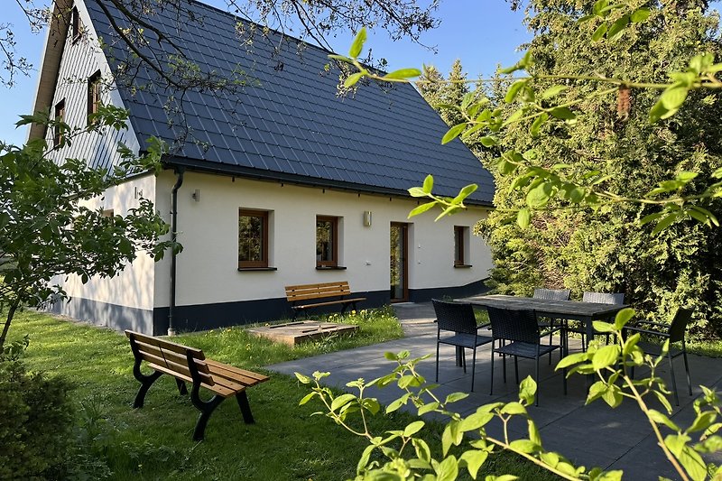 Rustikales Haus mit grünem Garten und blauem Himmel.