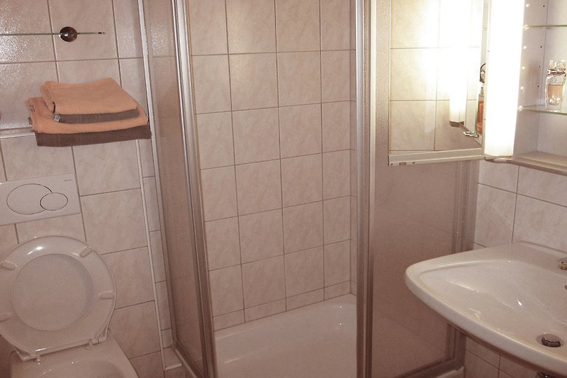 Gemütliches Badezimmer mit Fön, Handtücher und Kosmetikspiegel