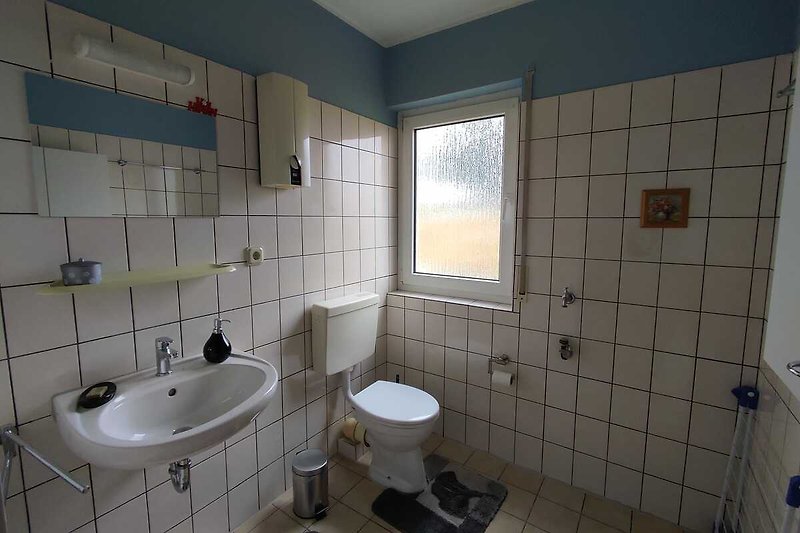 Modernes Badezimmer mit lila Akzenten, Fenster und Spiegel.