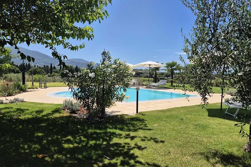 Ruhe und Erholung am privaten Pool, mit  bequemen Liegen mit Schatten unter den Palmen, Olivenbäumen oder den Schirmen.