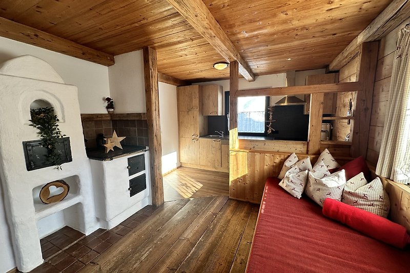 Gemütliches Wohnzimmer mit Holzboden, Fenster und gemütlicher Einrichtung.