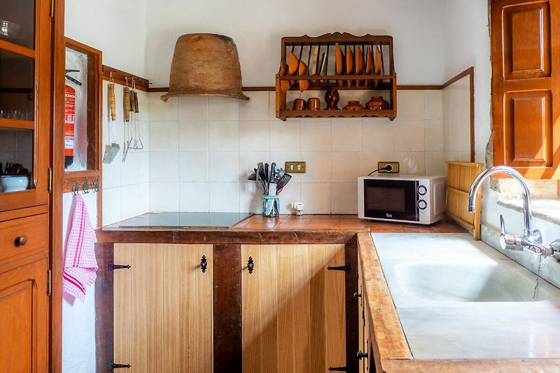 Hermosa cocina con encimeras de madera, fregadero y grifo.