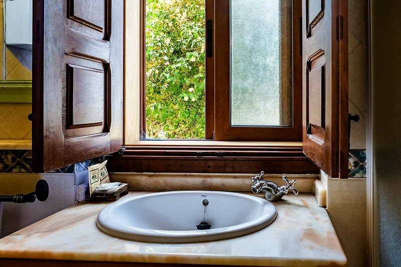 Hermoso baño con espejo, grifo y lavabo de madera.