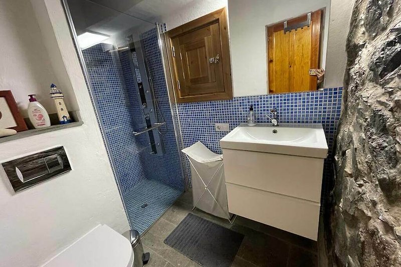 Hermoso baño morado con espejo y grifo elegante.