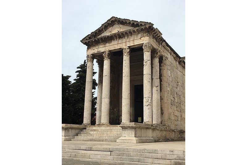 Antikes römisches Tempelruinen mit Säulen und Bäumen.