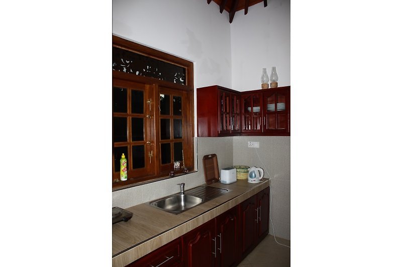 Kitchen of the bungalow with open archway access to the living area.