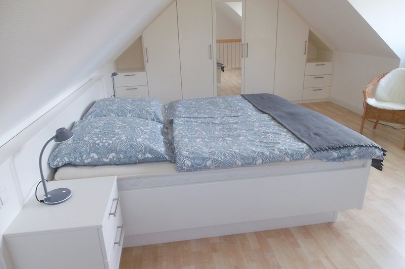 Komfortables Schlafzimmer mit Holzbett und Lampenschirm.