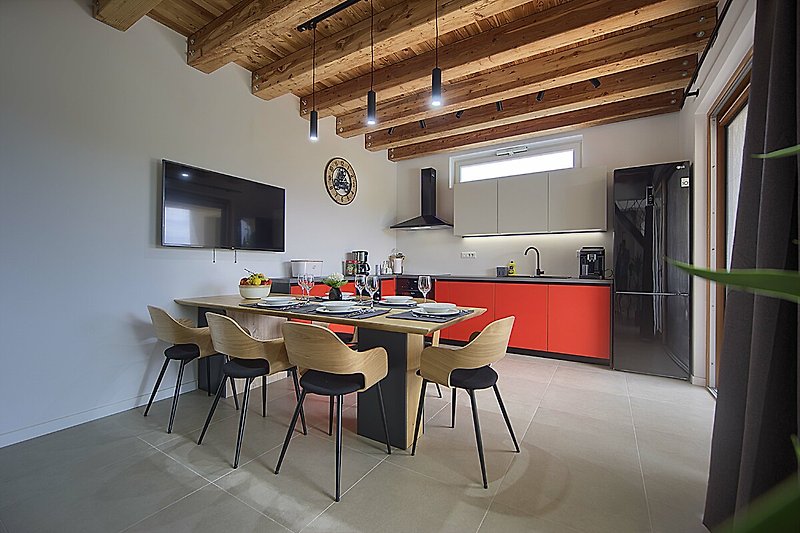 Udoban interijer s drvenim podom i modernim namještajem. Opuštanje uz udoban kauč i pripremu obroka u modernoj kuhinji.