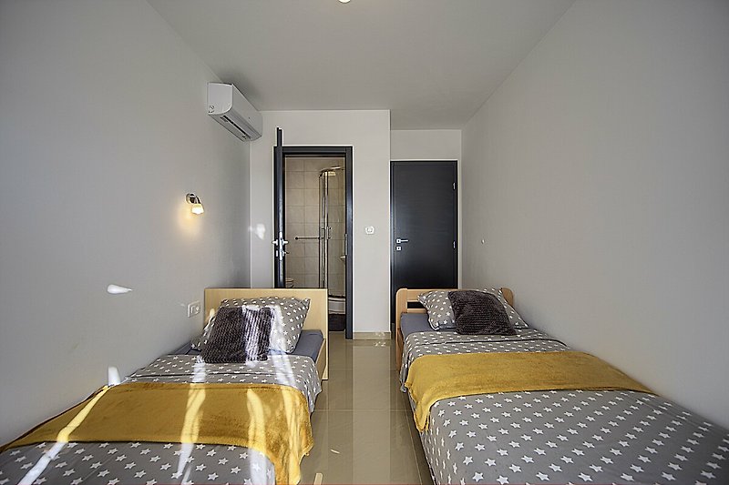 Udobna spavaća soba s lijepim osvjetljenjem i drvenim namještajem.