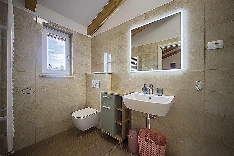 Lila Badezimmer mit Spiegel, Waschbecken und Armatur.