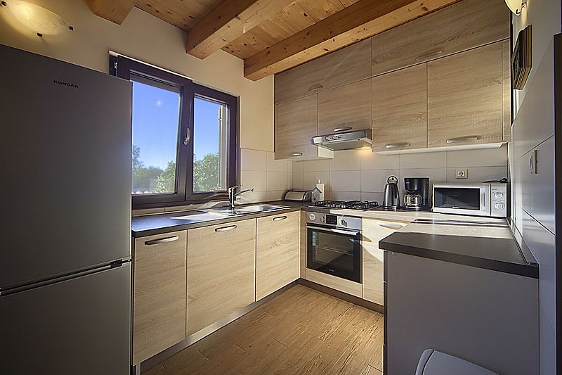 Prekrasan interijer s drvenim namještajem i modernom kuhinjom.