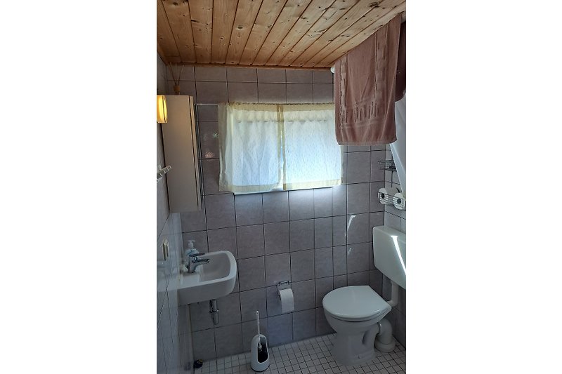 Schönes Badezimmer mit Holzboden, Spiegel und modernem Design.