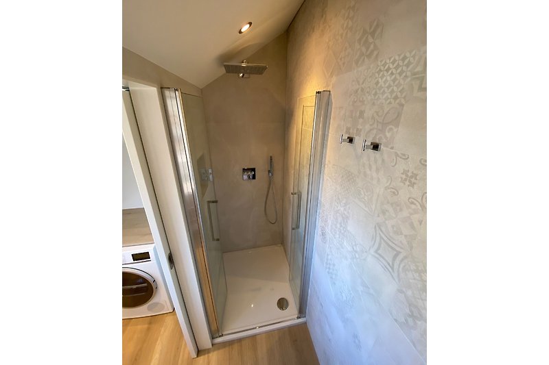 Nice shower with multiple settings and hand shower and a compartment on the left to put your things