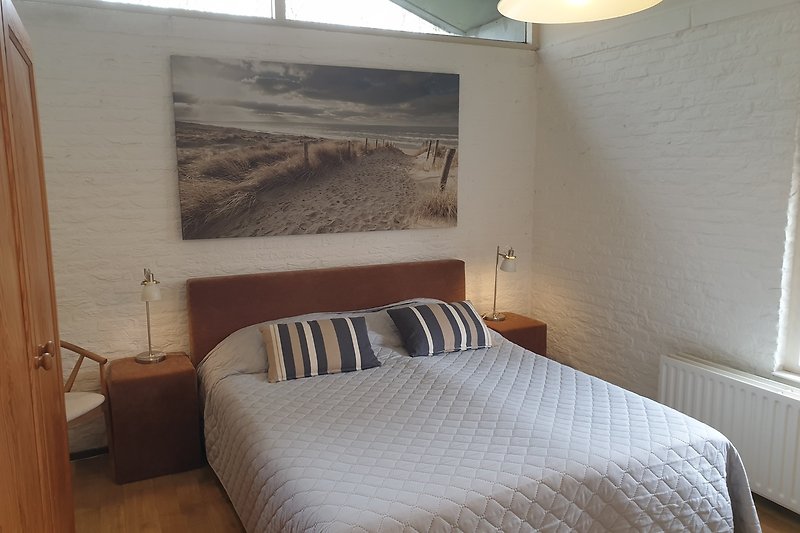 Modernes Schlafzimmer mit stilvoller Beleuchtung und gemütlichem Bett.