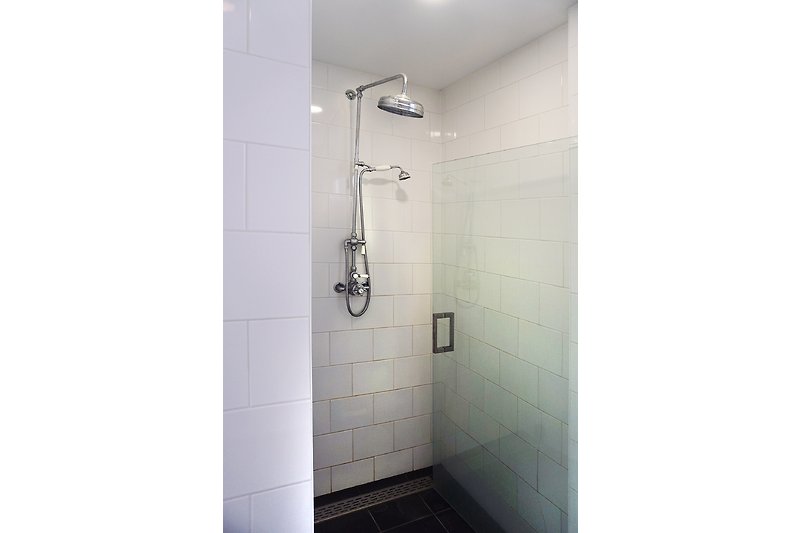 Modernes Badezimmer mit stilvoller Dusche und gläserner Duschwand.