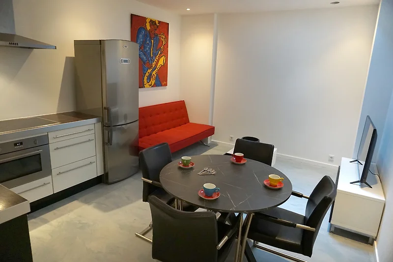 Wohnzimmer mit Holztisch, Sofa und Fernseher.