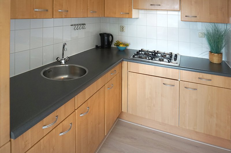 Moderne Küche mit Holzschränken, Arbeitsplatte und Küchenspüle.