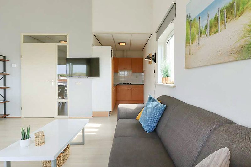 Gemütliches Wohnzimmer mit Holzmöbeln, Couch und Tisch.