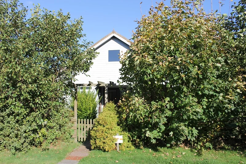 Het huis met omheinde tuin.