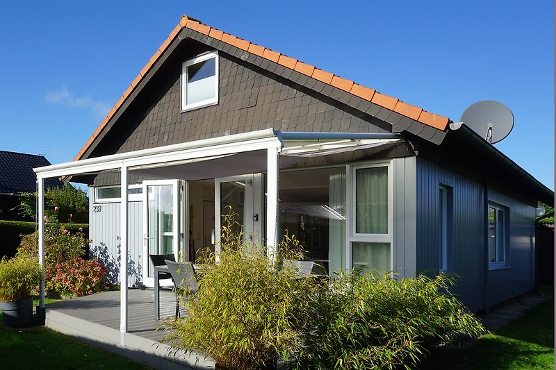 Charmantes Landhaus mit Holzfassade und einladender Veranda.