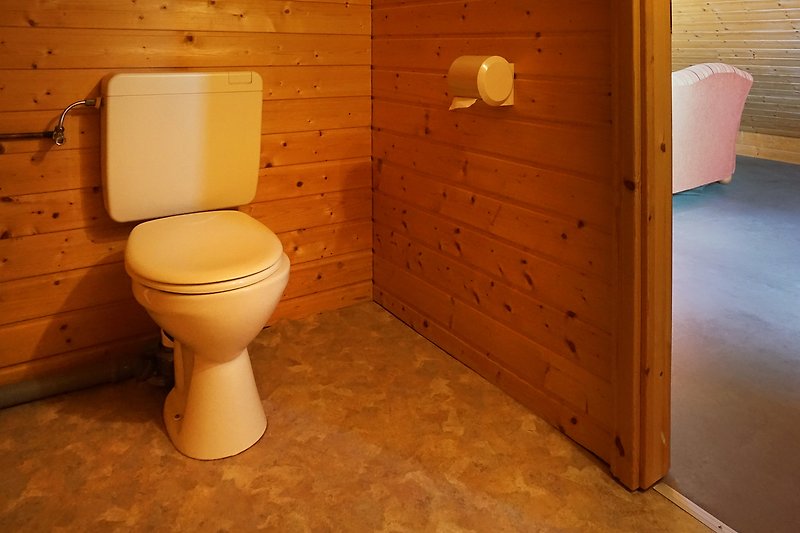 Ein helles Badezimmer mit Holzakzenten und Keramikfliesen.