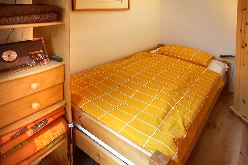 Schlafzimmer mit Holzmöbeln und gemütlichem Bett.