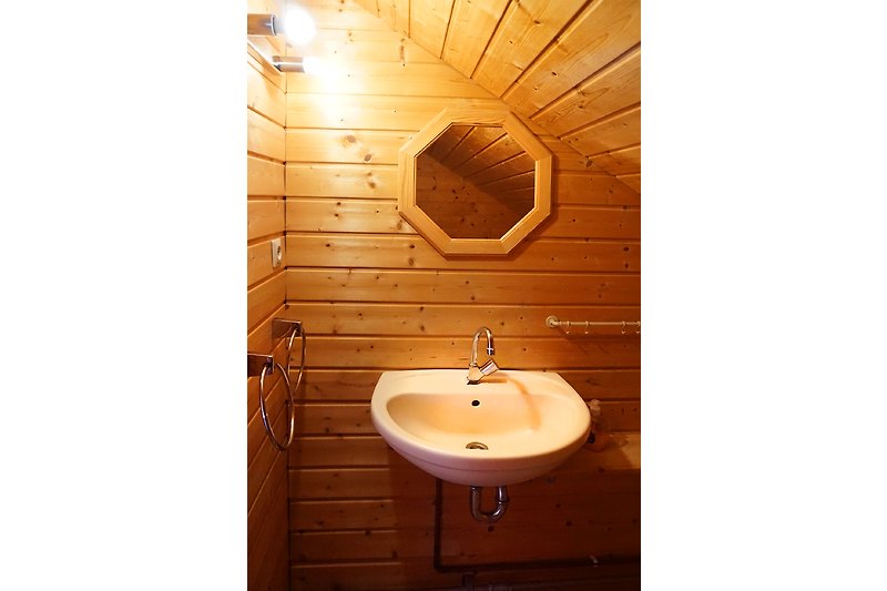 Ein modernes Badezimmer mit Holzakzenten und Spiegel.