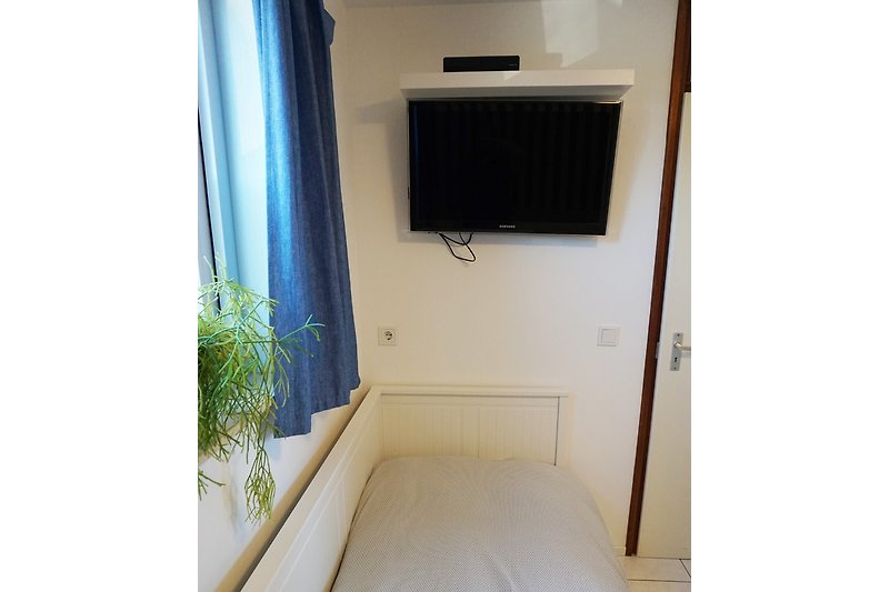 Schlafzimmer mit zwei Einzelbetten und Fernseher