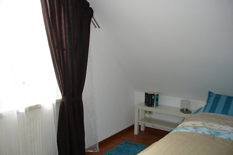 Elternschlafzimmer mit  Doppelbett 1,80 m und Babygitterbett - Ferienhaus Brachvogelweg, Nessmersiel
