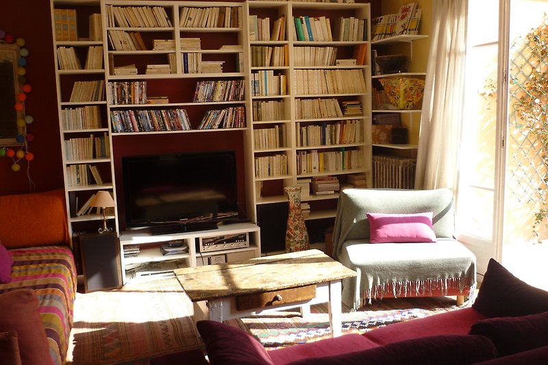 Magnifique salon avec des meubles en bois, une étagère remplie de livres et une lampe chaleureuse.