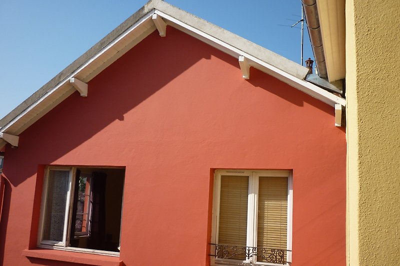 Une maison charmante avec une façade colorée  et des fenêtres élégantes.