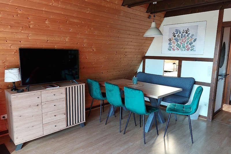 Gemütliches Wohnzimmer mit Holzmöbeln und Fernseher.