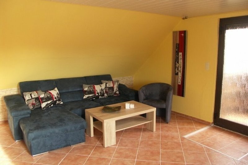 Stilvolles Wohnzimmer mit Holzmöbeln, Pflanzen und gemütlicher Couch.