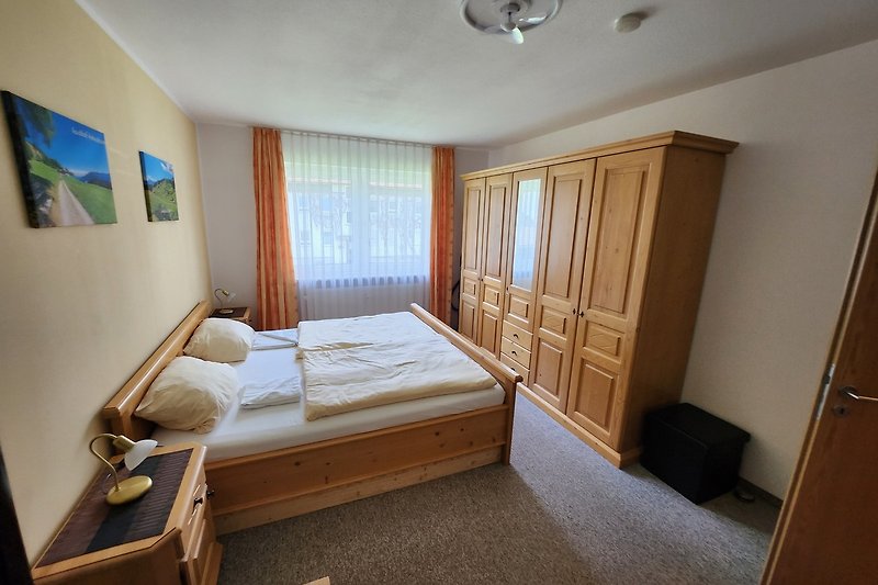 Gemütliches Schlafzimmer mit stilvollem Holzmöbel und bequemem Bett.