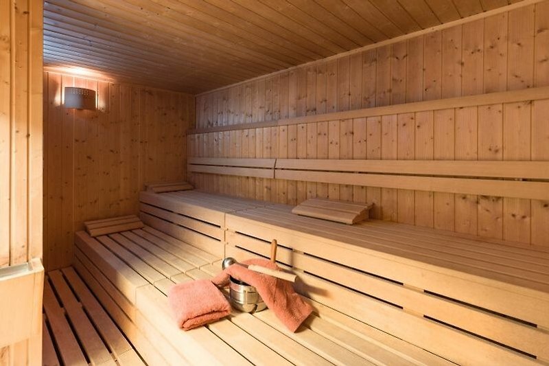 Gemütliches Holzhaus mit Sauna, Fenstern und schöner Landschaft.