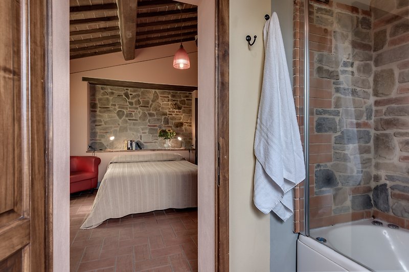 Verbringen Sie Ihren Urlaub in diesem stilvoll eingerichteten Badezimmer mit Holzmöbeln und entspannen Sie in der Badewanne.