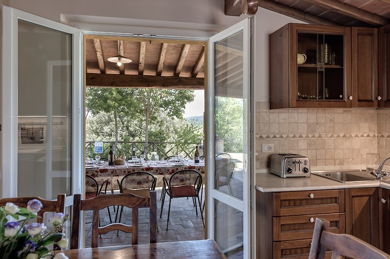 Verbringen Sie Ihren Urlaub in dieser charmanten Küche mit Holzmöbeln und Blick auf die Landschaft. Genießen Sie das Kochen und Essen in diesem gemütlichen Raum.