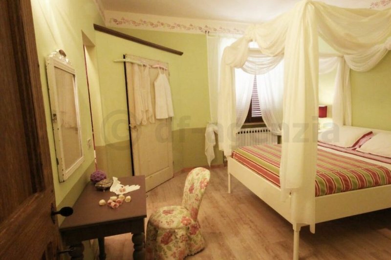 Romanrisches Schlafzimmer mit stilvoller Einrichtung und Holzdetails.