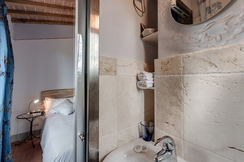 Verbringen Sie Ihren Urlaub in diesem stilvoll eingerichteten Badezimmer mit modernem Waschbecken und entspannen Sie in der Badewanne.
