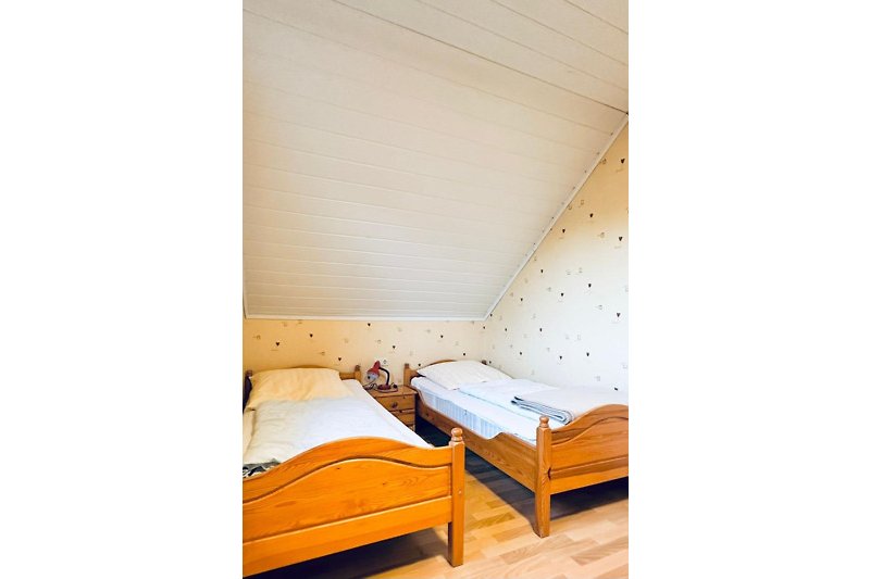 Gemütliches Schlafzimmer mit bequemem Bett und stilvollem Holzmöbel.