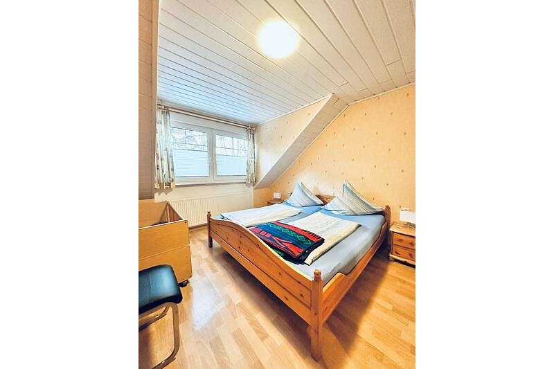 Gemütliches Schlafzimmer mit bequemem Bett und Holzmöbeln.