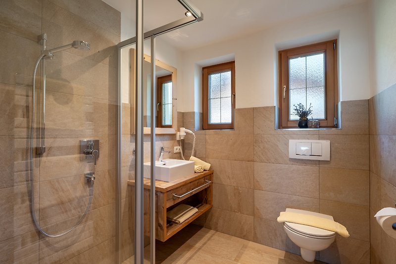 Ein stilvolles Badezimmer mit modernen Armaturen und einer geräumigen Dusche.